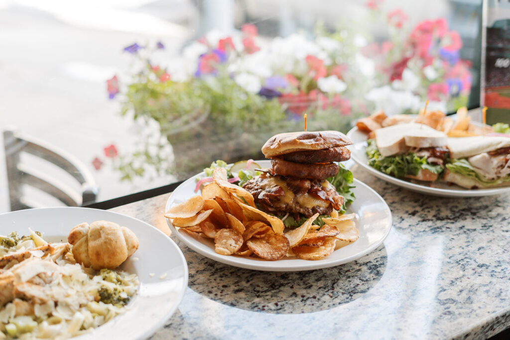 Chicken brocolli alfredo, the Cowboy burger and the turkey club, on the counter at Brewhouse District