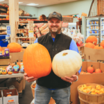 A man holding pumpkins at Lee's Market