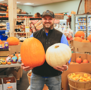 A man holding pumpkins at Lee's Market