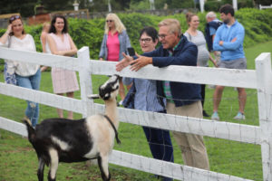Couple greeting a goat at West Place Animal Sanctuary