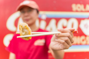 Sola holding a dumpling with chopsticks