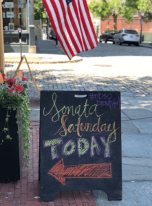 cobblestones, flag and sign for Sonata Saturdays in downtown New Bedford