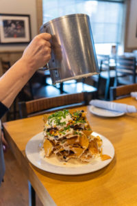 presenting the nachos at the table
