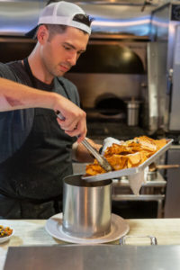 Chef moving nachos into can