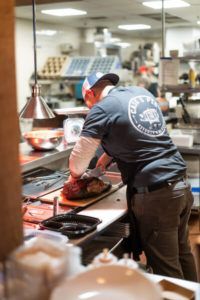 Chef carving beef brisket at Cask & Pig