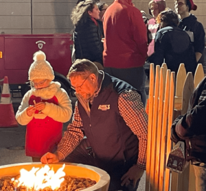 A man and child gathering at a firepit