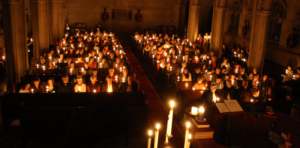 a congregation filled with people holding lit candles