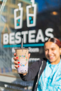 Julia holding a tea outside the front door of BesTeas