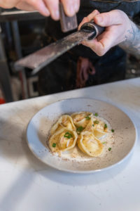 Grating chocolate on the lobster tortellini