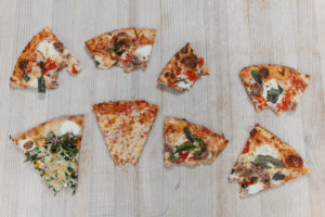 Half eaten slices of pizza on a butcher block