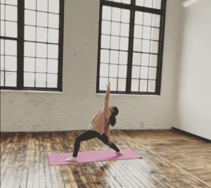 A yoga pose in front of the windows at Kilburn Mill