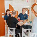 Bree and Marc chatting with customers at the bar of Cast