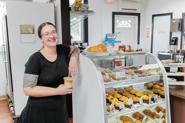 Joni Rhodes leaning against her pastry case at The Rescue Cafe