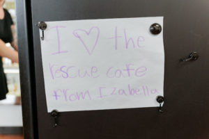 A handwritten sign: "I love the Rescue Cafe"