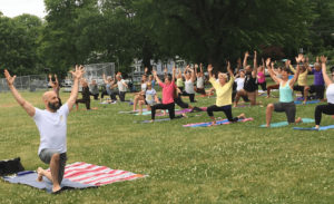 yoga at Cushman park with a crowd of people