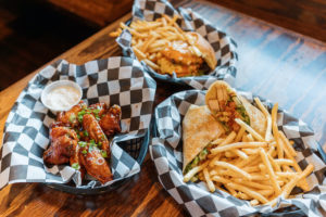 Baskets of wings, a chicken caesar wrap and a smash burger
