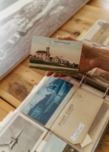 A hand holding a vintage postcard