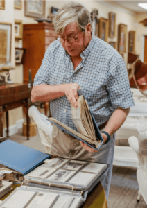 Frank McNamee pages through some postcard albums