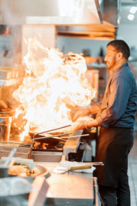 Cooking at the stove with flames reaching up