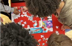Heads leaning over a jigsaw puzzle
