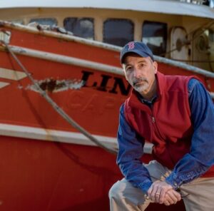 Phil Mello in front of a fishing vessel