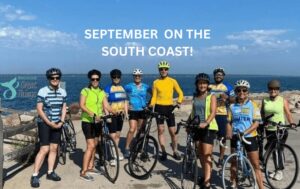 Bike riders in front of the water with title: September on the South Coast