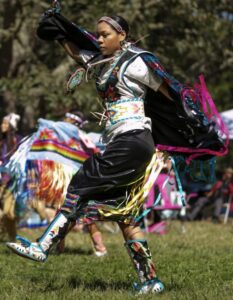 a young girl dancing during a powwow