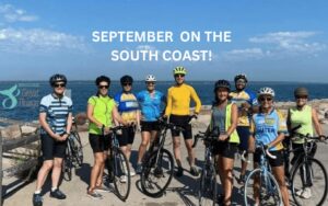 Bike riders in front of the water with title: September on the South Coast