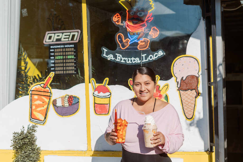 Jackie, standing outside La Fruta Loca shop with the mangonada and