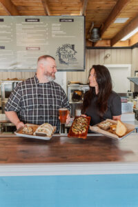 Andy & Ellen smiling at each other at the counter of HomeRootts Bistro