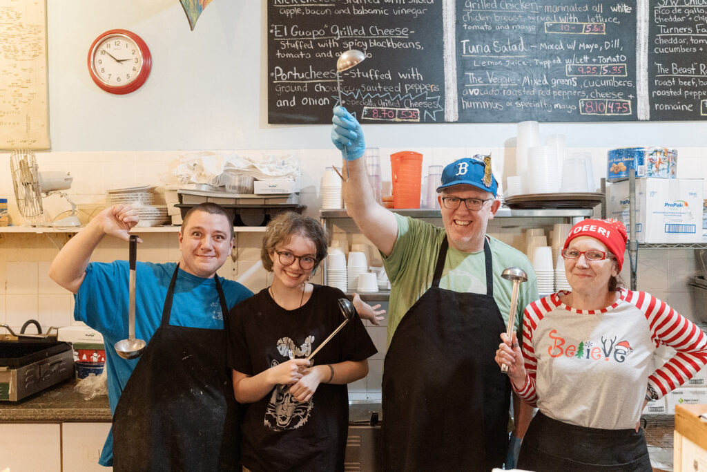 Staff at destination soup, smiling behind the counter