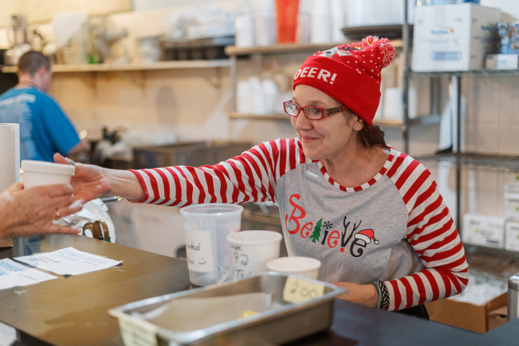 Cheryl handing a soup to a customer