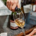someone pouring a glass of white wine