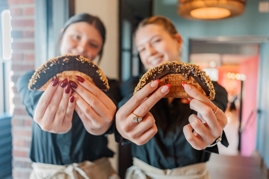 Two servers hold out the Choco Tacos for a photo