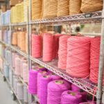 Weaver Phonn Phan at the dobby loom with undyed wool creel