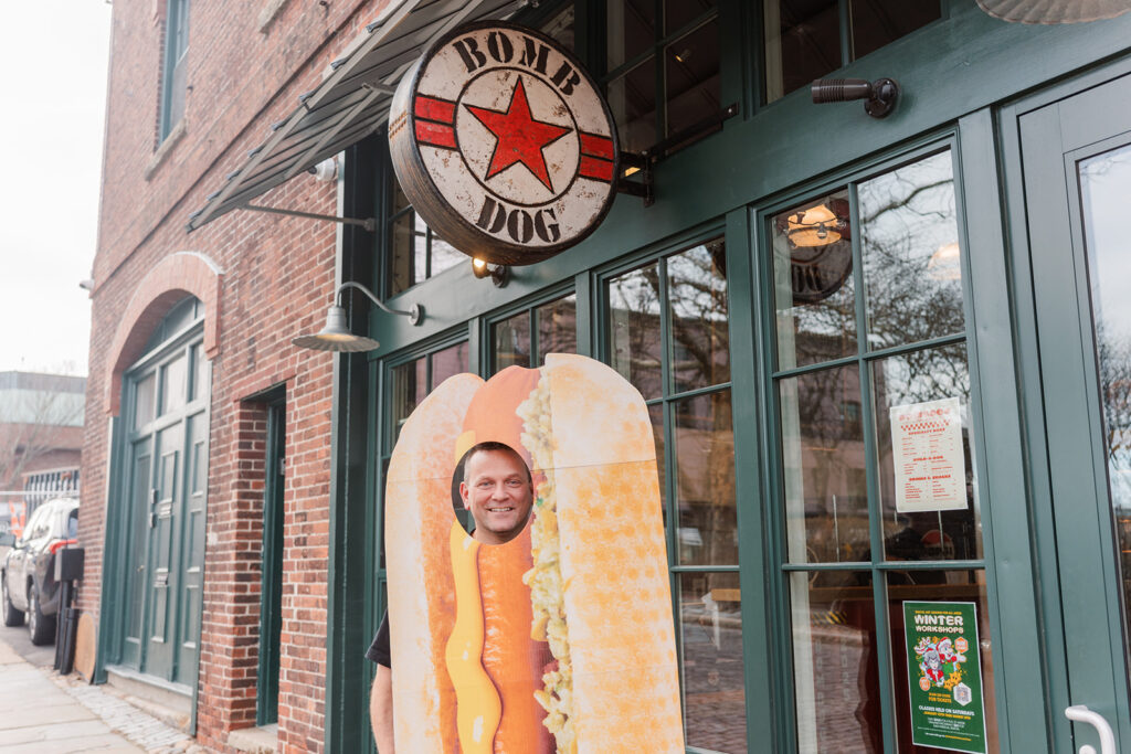 Adam standing outside Bomb Dog, in a hot dog costume