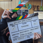Someone holding up a movie clapperboard