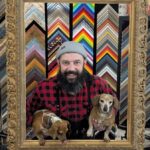 The owner of Art Box in his shop with his two dogs