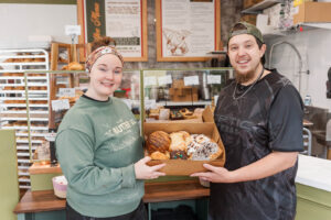 Allie and Mike at their bakery holding a box of treats