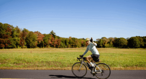 A watershed rider bicycling with a field in the background