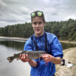 a boy holding a fish at Fearing pond