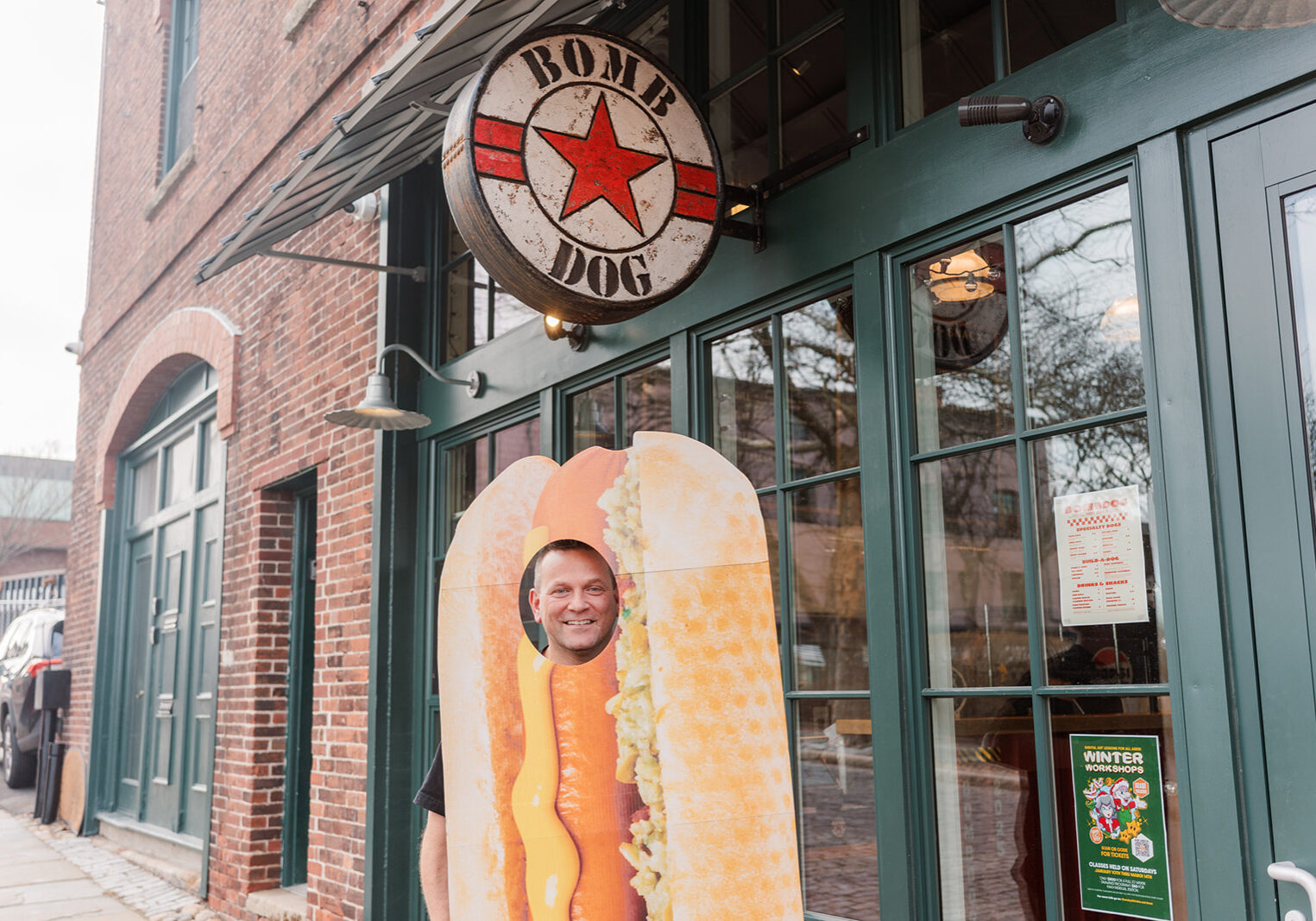 Adam standing outside Bomb Dog, in a hot dog costume
