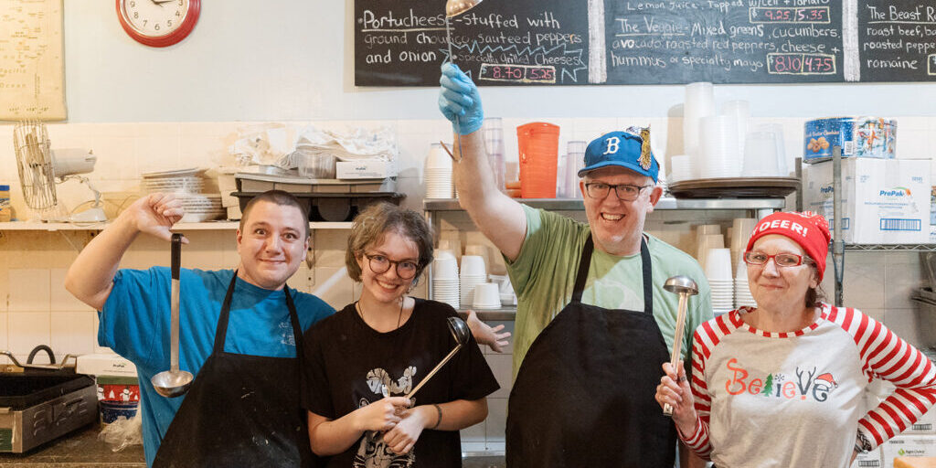 Staff at destination soup, smiling behind the counter