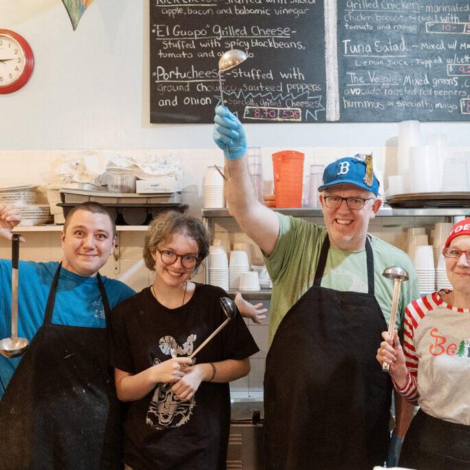 Staff at destination soup, smiling behind the counter