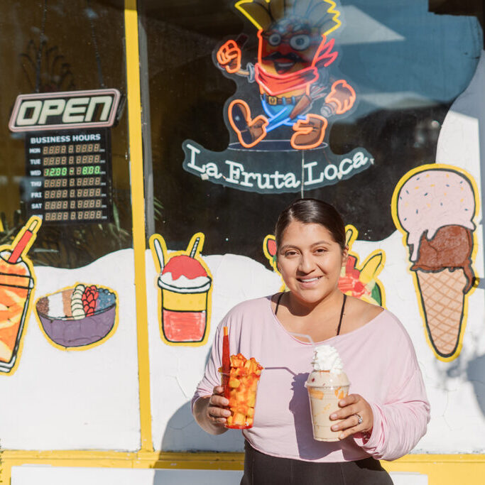 Jackie, standing outside La Fruta Loca shop with the mangonada and