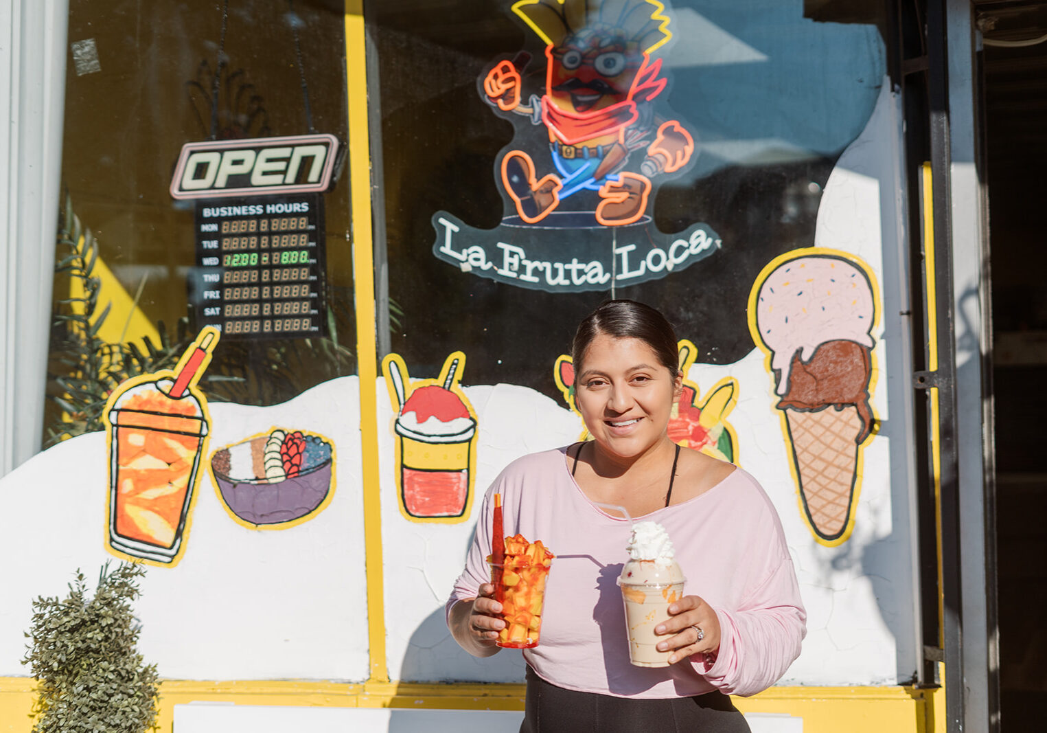 Jackie, standing outside La Fruta Loca shop with the mangonada and