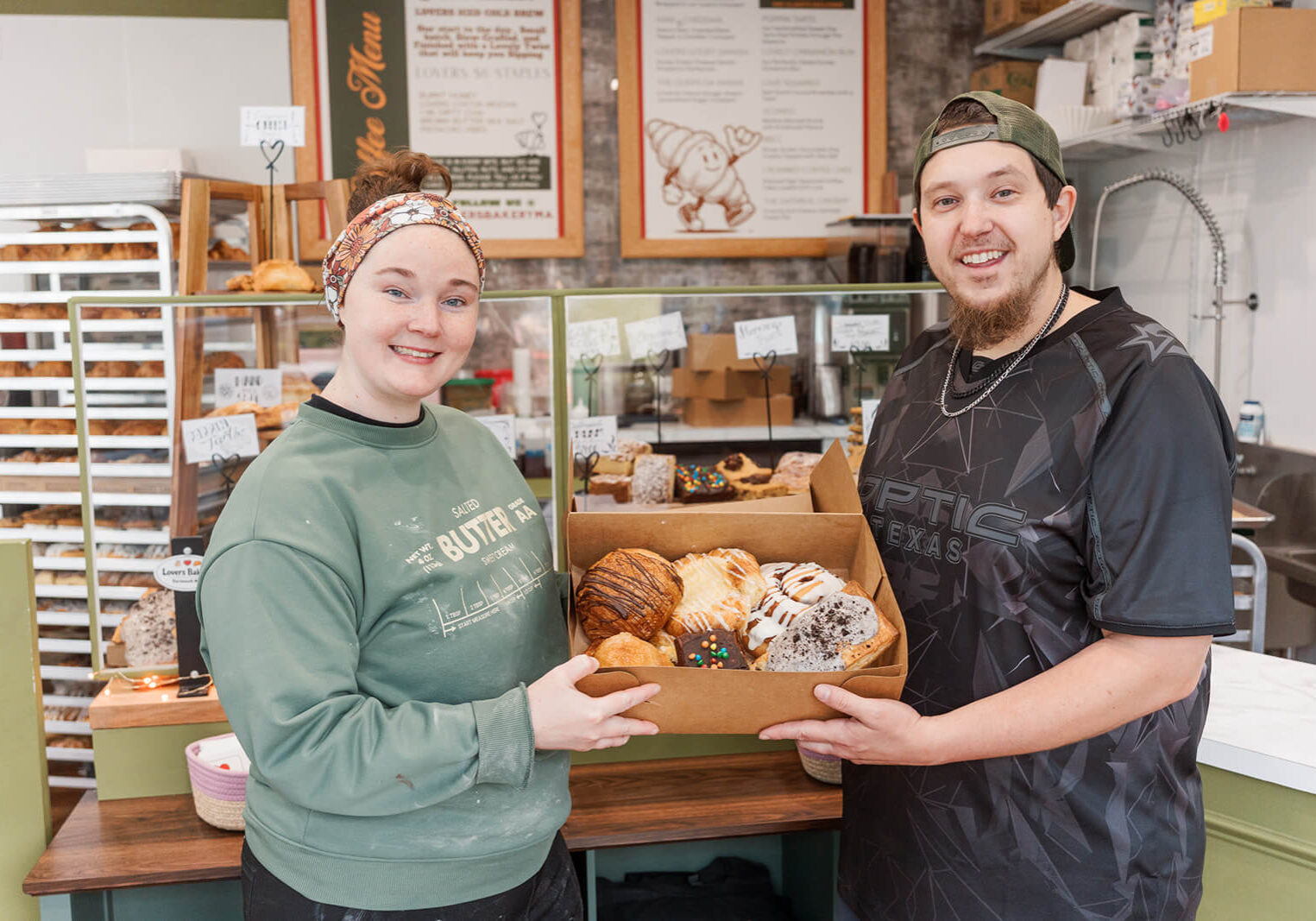Allie and Mike at their bakery holding a box of treats