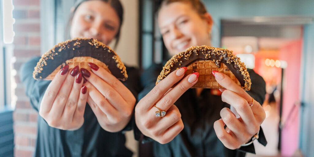 Two servers hold out the Choco Tacos for a photo