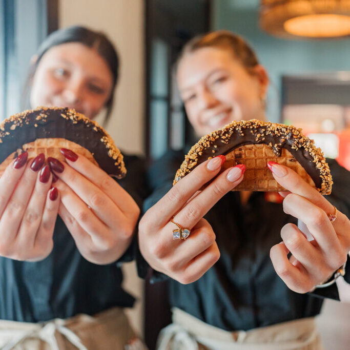 Two servers hold out the Choco Tacos for a photo