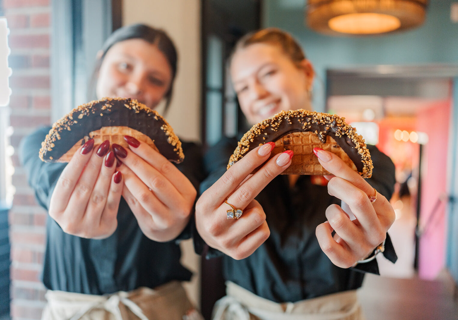 Two servers hold out the Choco Tacos for a photo